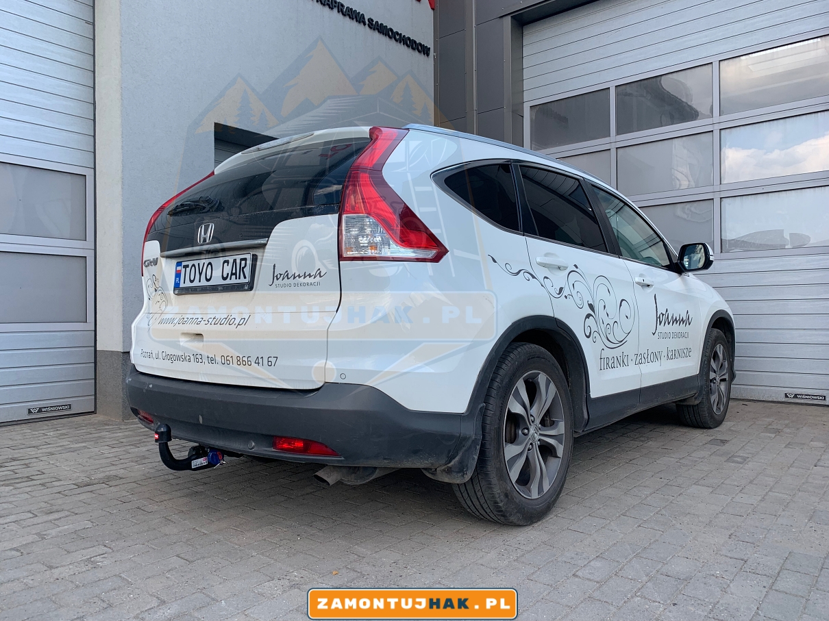 Zdjęcie przedstawia Hondę CR-V z zamontowanym wypinanym pionowo hakiem holowniczym westfalia a40v, zdjęcie jest zrobione z tyłu z praej strony samochodu